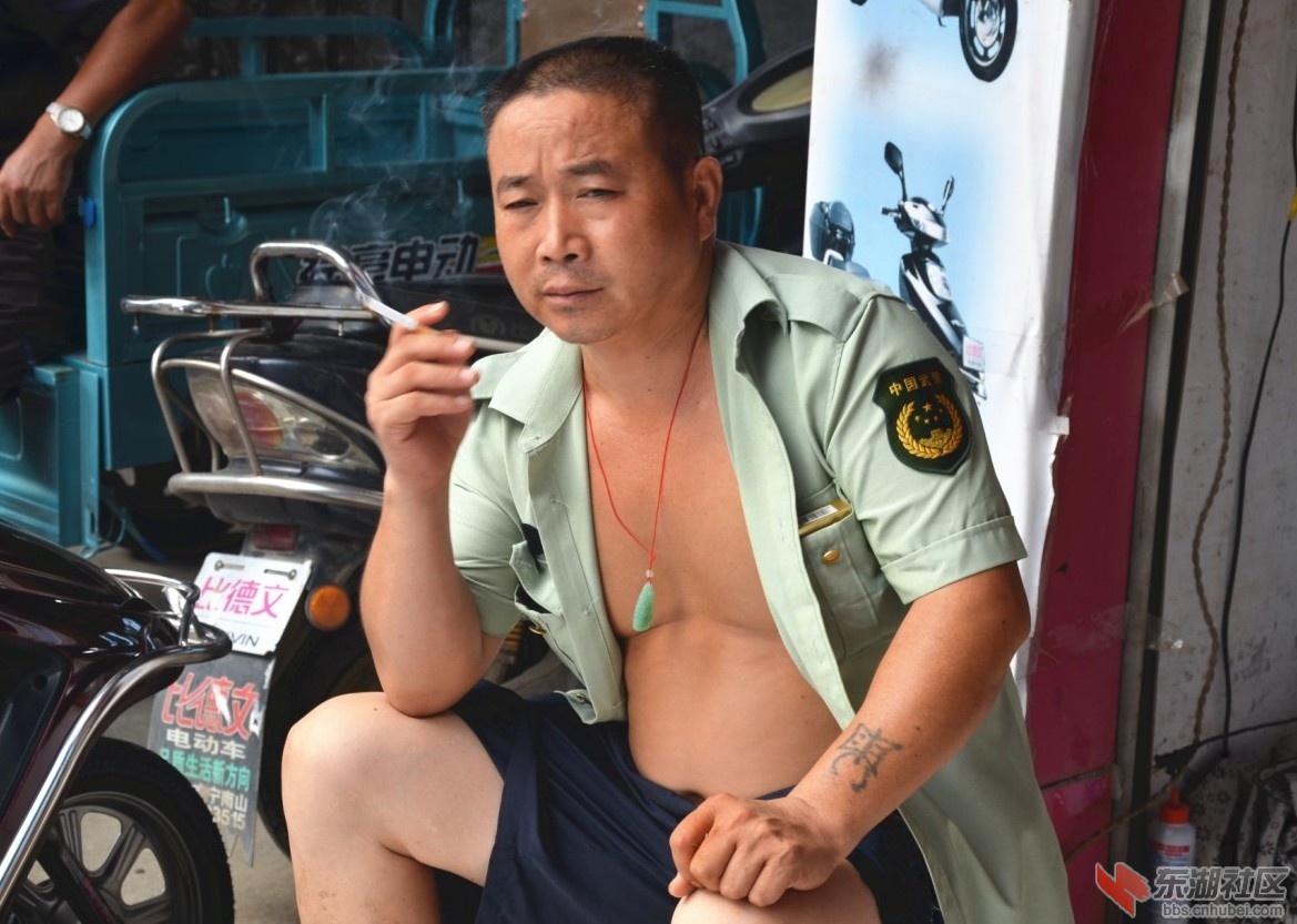 湖北一男子身着07式武警短袖衫坦胸露乳抽烟