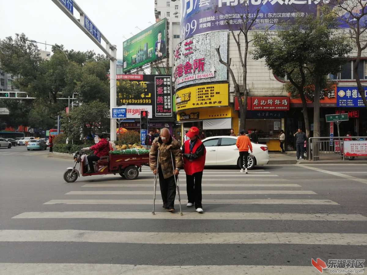 志愿者热心的搀扶老人过马路