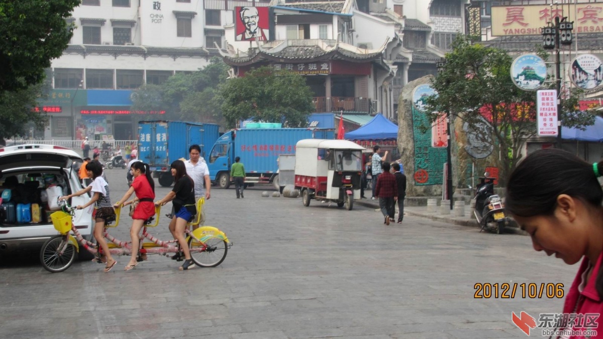 阳朔西街。三个美眉学骑三人自行车。