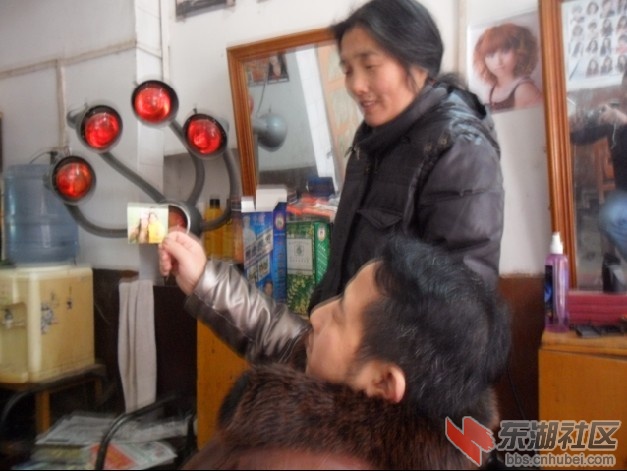 图3：空闲时，他和妻子看着两个懂事姑娘的照片很开心.jpg