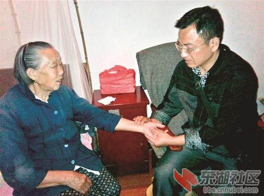 图为：郭怀德正在给老人看病