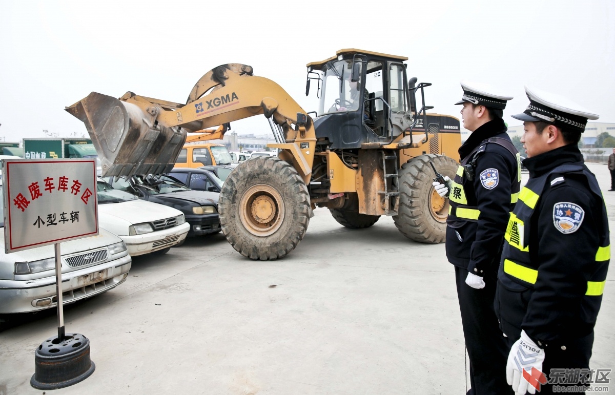 图为在民警监督指挥下，工作人员有序对车辆进行解体报废。