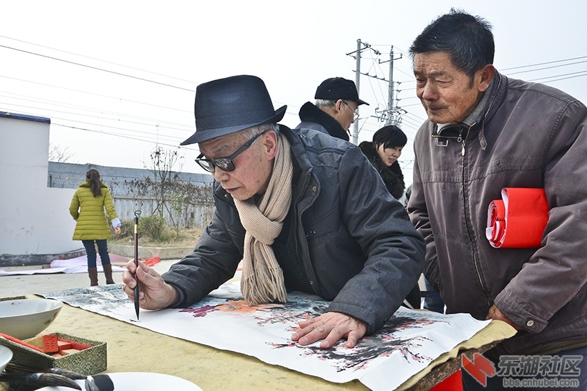 老年书画家谈华稳为农民作年画。