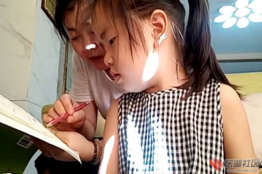 图为小朋友的家长正在就课堂上的数学题和数学作业进行耐心地讲解.png.png